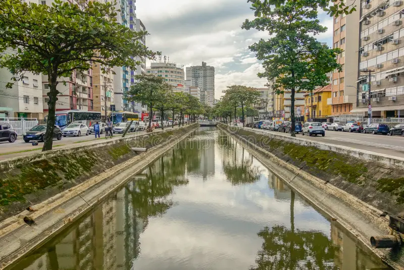 Por que Santos tem tantos canais? A história da engenharia que mudou a cidade foto panorâmica da orla de santos com um canal chegando ao mar