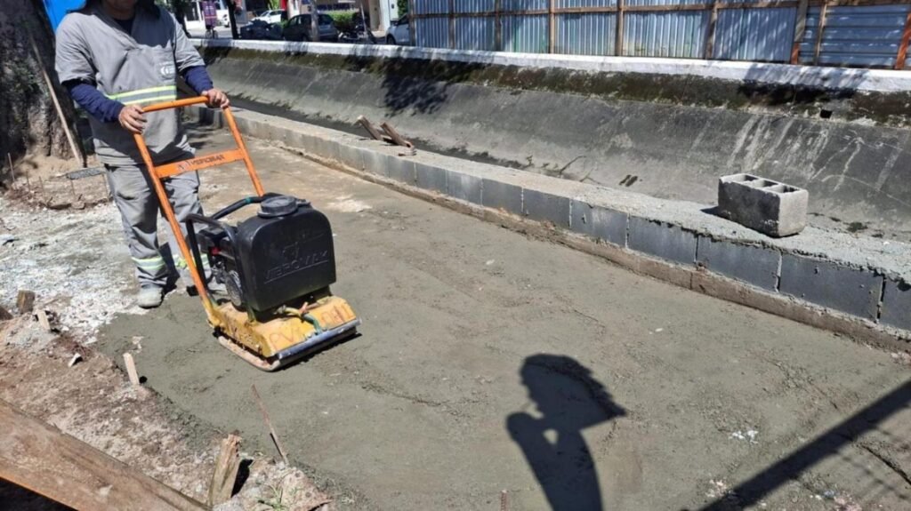 Obra no Canal 4 inclui reparos além da ciclovia Trabalhador compacta o solo junto à margem do Canal 4, em Santos.