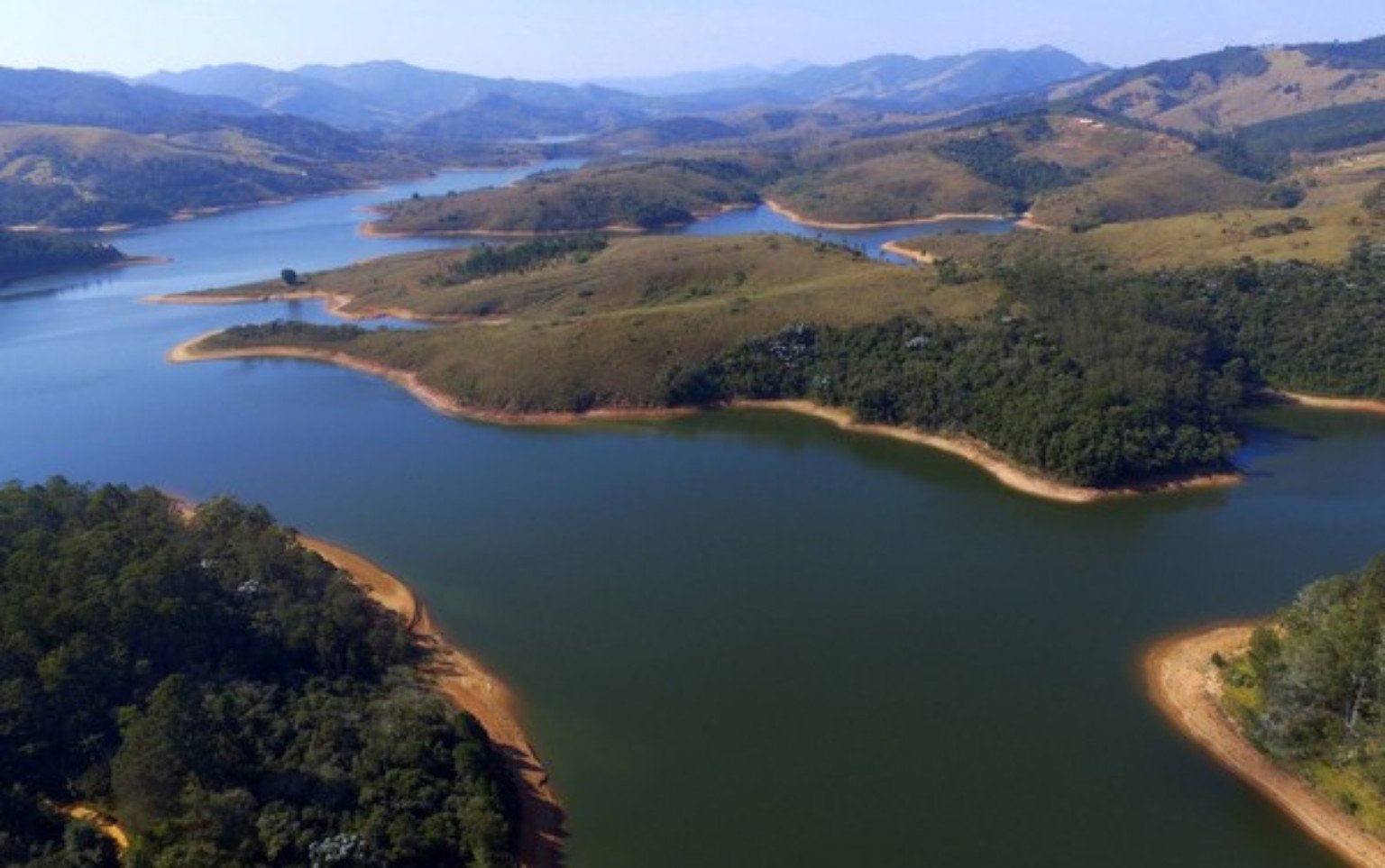 Cantareira cai a 33% e segue em alerta Vista aérea de reservatório do Sistema Cantareira com montanhas ao redor