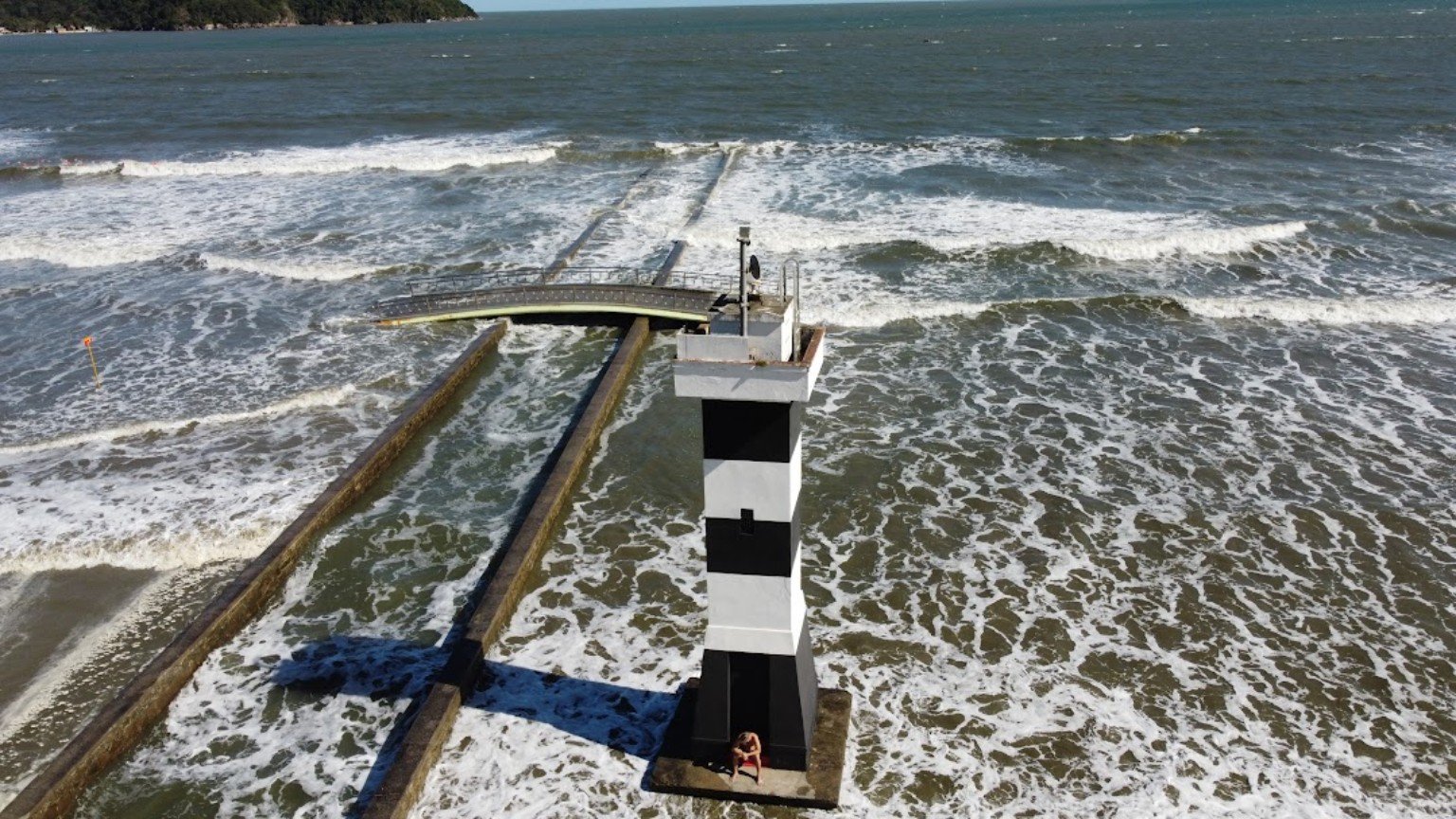 Marinha alerta para ressaca entre Santos e Arraial Mar agitado ao redor de estrutura de sinalização marítima no litoral