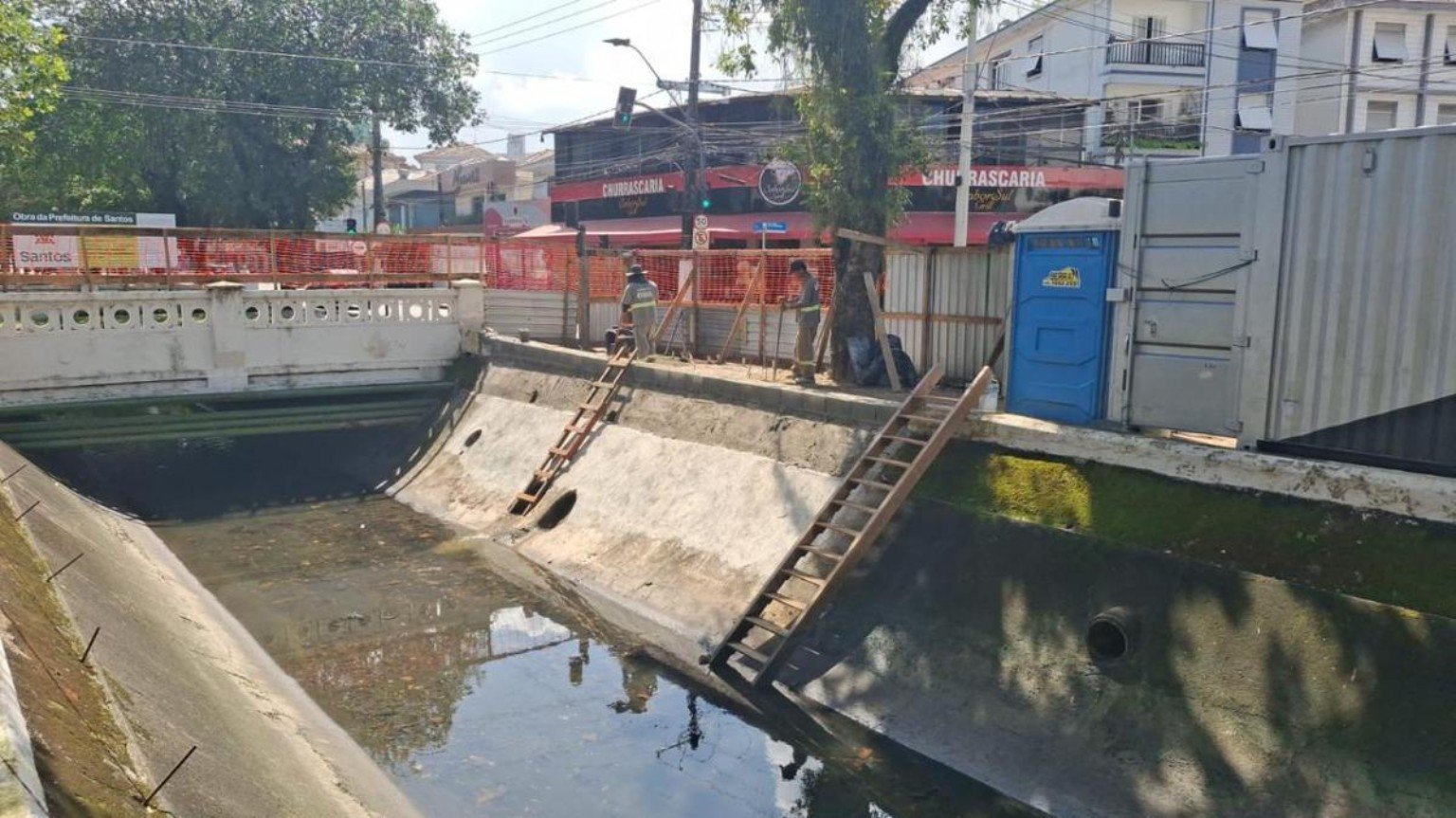 Trecho do Canal 4 com escadas, trabalhadores e isolamento durante obras em Santos.
