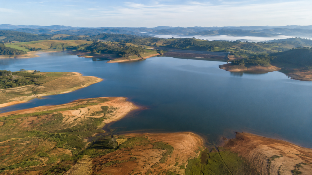Vista aérea de reservatório com faixas de solo expostas nas margens