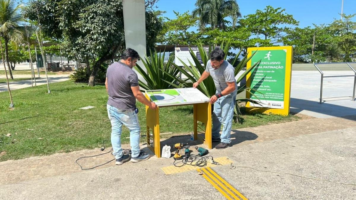 Quebra-Mar recebe mapas táteis; rota ainda será concluída Trabalhadores instalam mapa tátil junto à pista de patinação do Novo Quebra-Mar, em Santos.